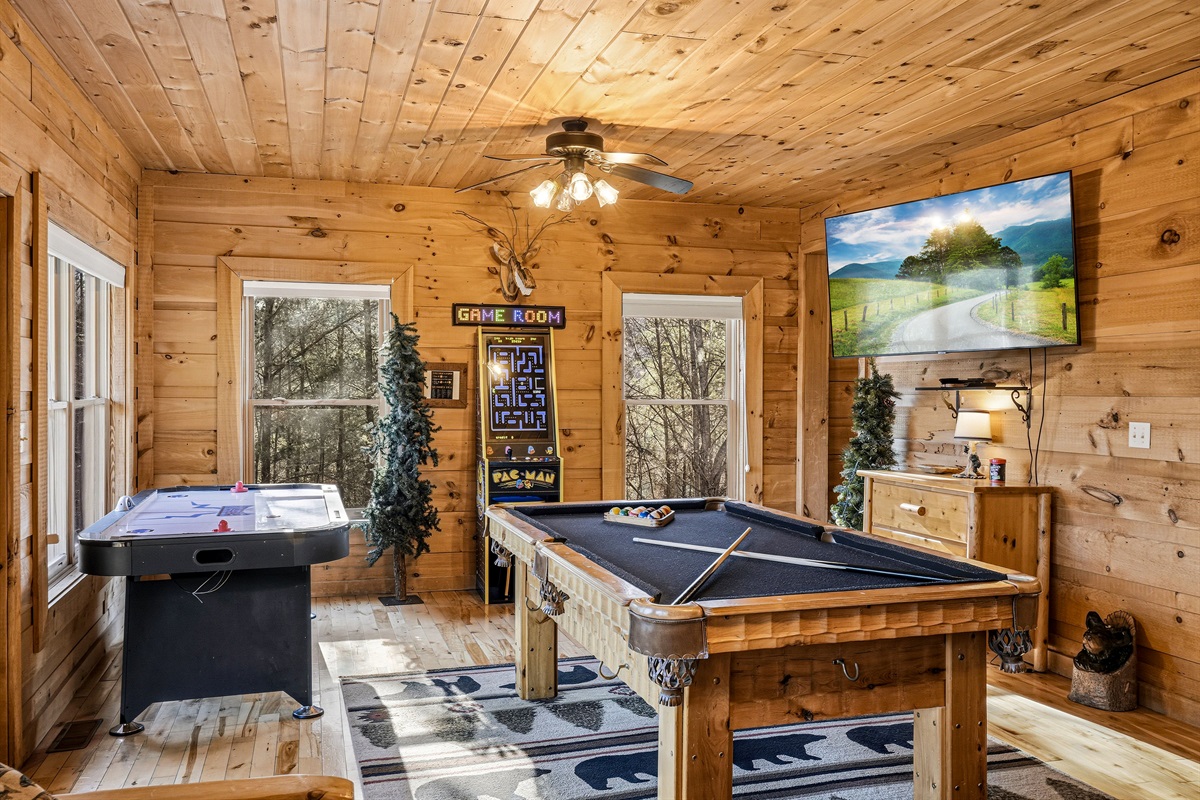 Rainy day in the Smokies? No problem &mdash; the "Hibernation Station" game room has you covered | This Gatlinburg-area cabin features a full pool table, air hockey table, bunk beds & flat screen TV for endless indoor fun | The ultimate family cabin rental