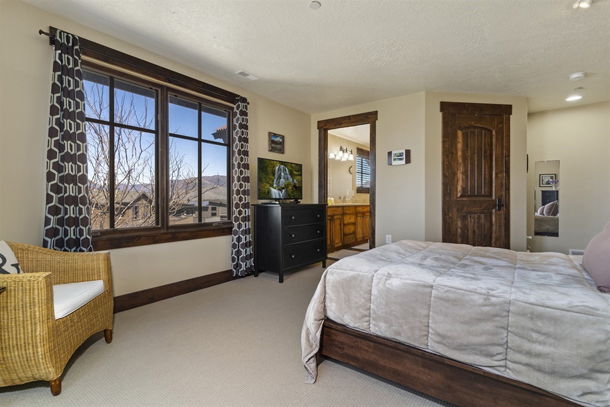 Wake up to breathtaking scenery in this light-filled bedroom, where oversized windows and elegant touches create a calm, elevated atmosphere.