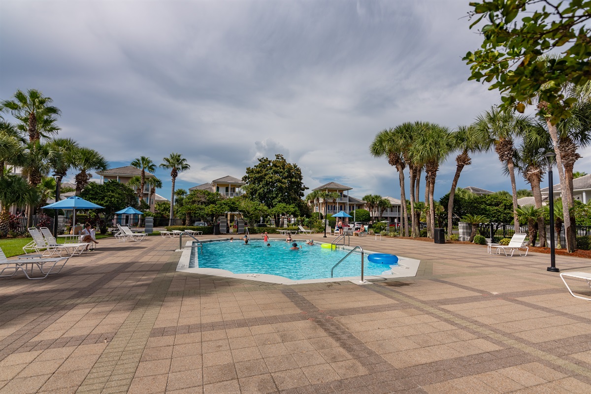 Resort‑style pool area with umbrellas and seating