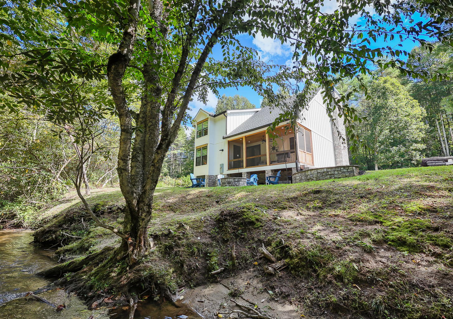 Enjoy the sounds of flowing water just steps from Robbin’s Nest on Snowbird Creek, with outdoor seating surrounded by shade trees.