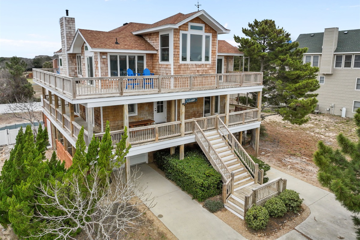 Front exterior with wraparound porches and a welcoming entry.