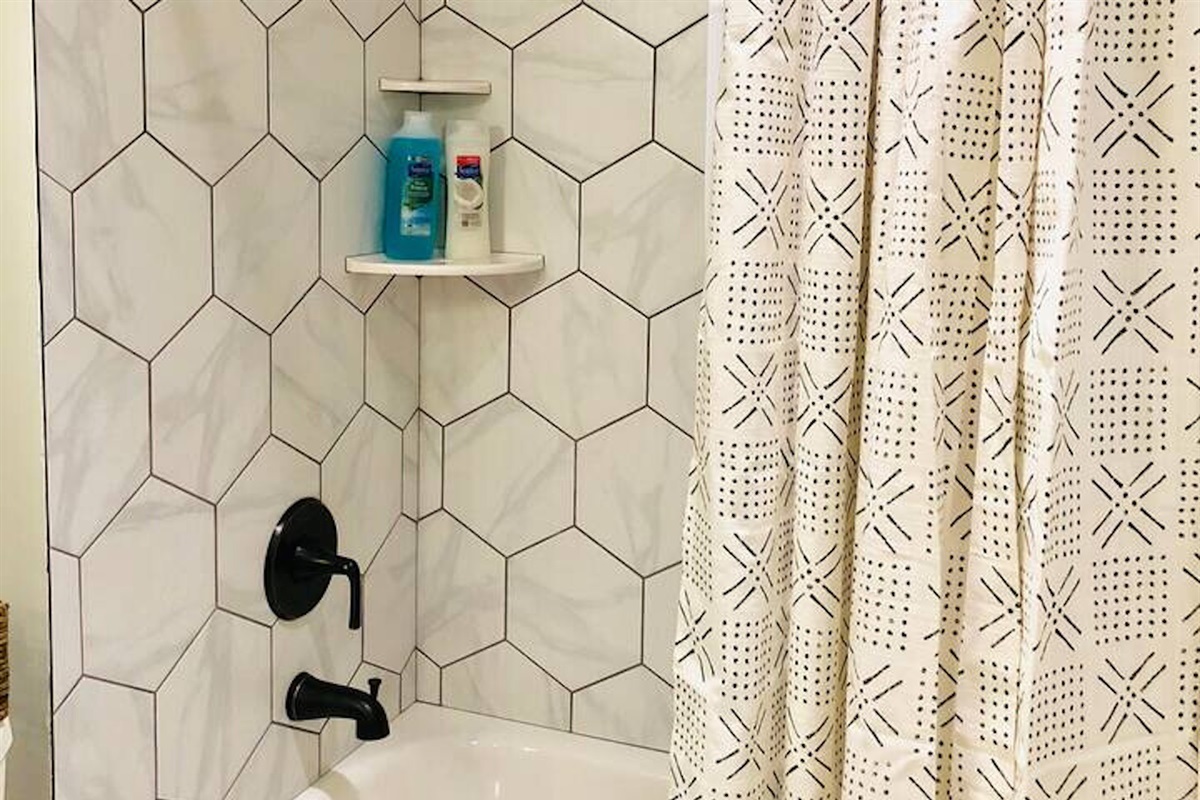 Unit A - The fourth bathroom features charming honeycomb tiles and upgraded fixtures.