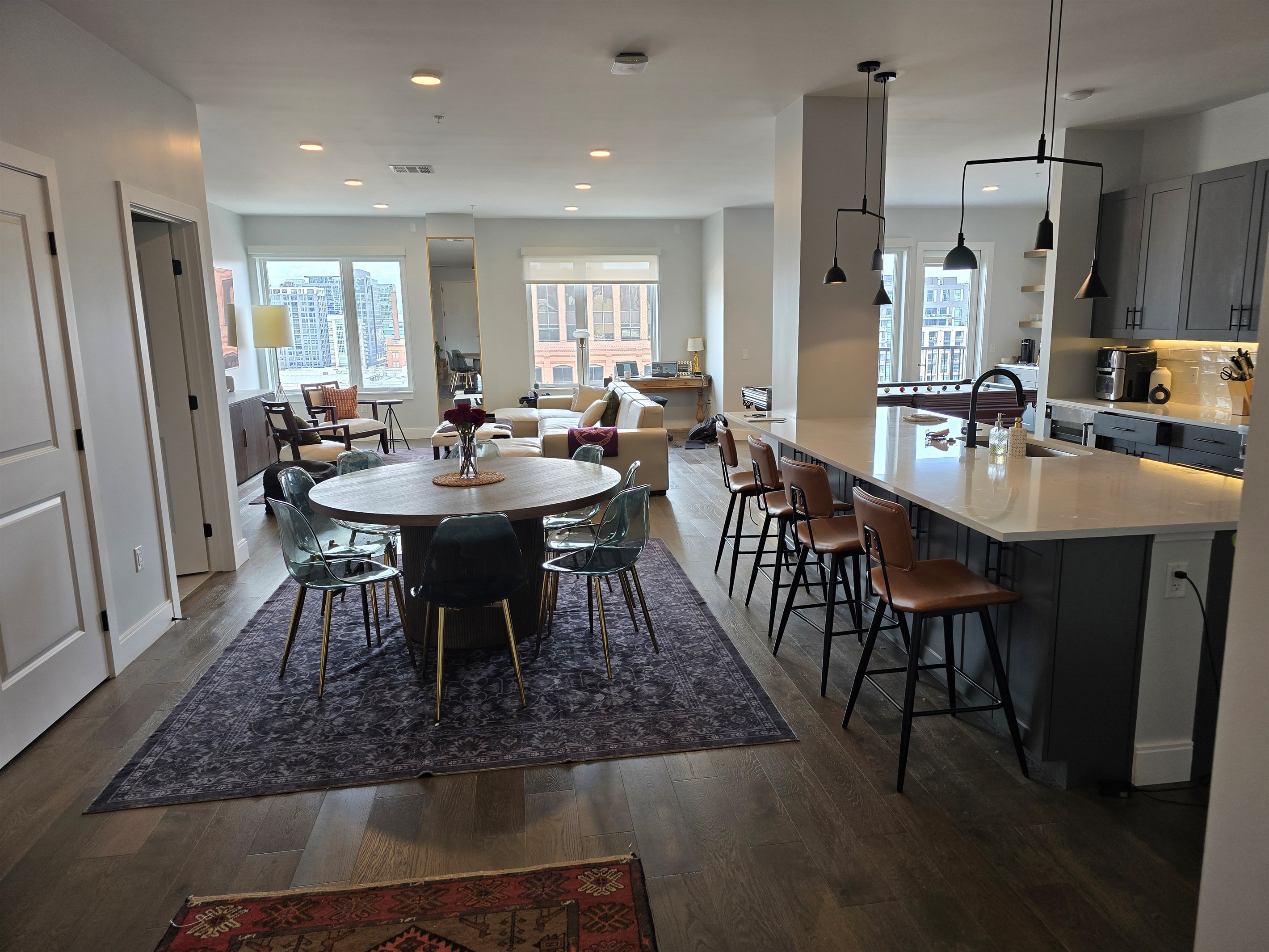 The full kitchen bar and dining room seating looking into the living room