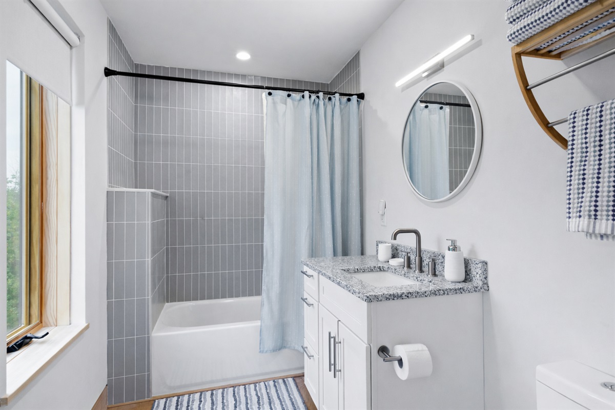 The full bathroom on the second floor is tucked away on the backside of the open concept living room and kitchen for privacy