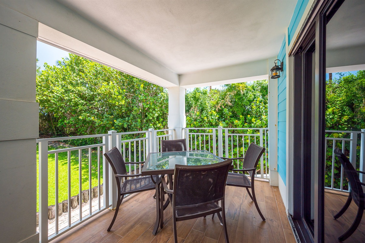 Private balcony surrounded by lush greenery, featuring outdoor dining and seating—perfect for morning coffee, al fresco meals, or evening relaxation.