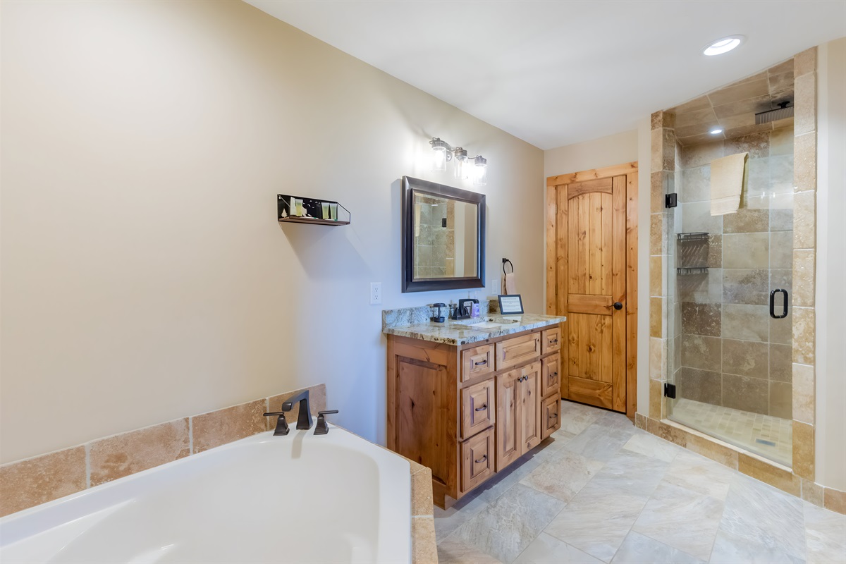 The lower level bedroom has an ensuite bathroom with a large tub, shower and sink.