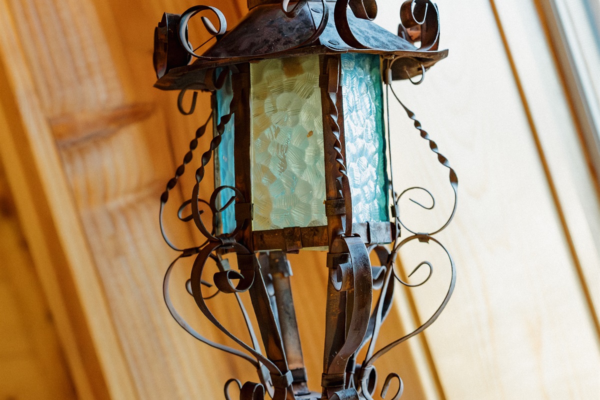 Handcrafted wrought iron lighting fixtures add authentic gothic western character throughout Poppywood Pines. This unique Show Low A-frame features artisan details and dramatic design elements, creating an unforgettable White Mountains vacation rental expe