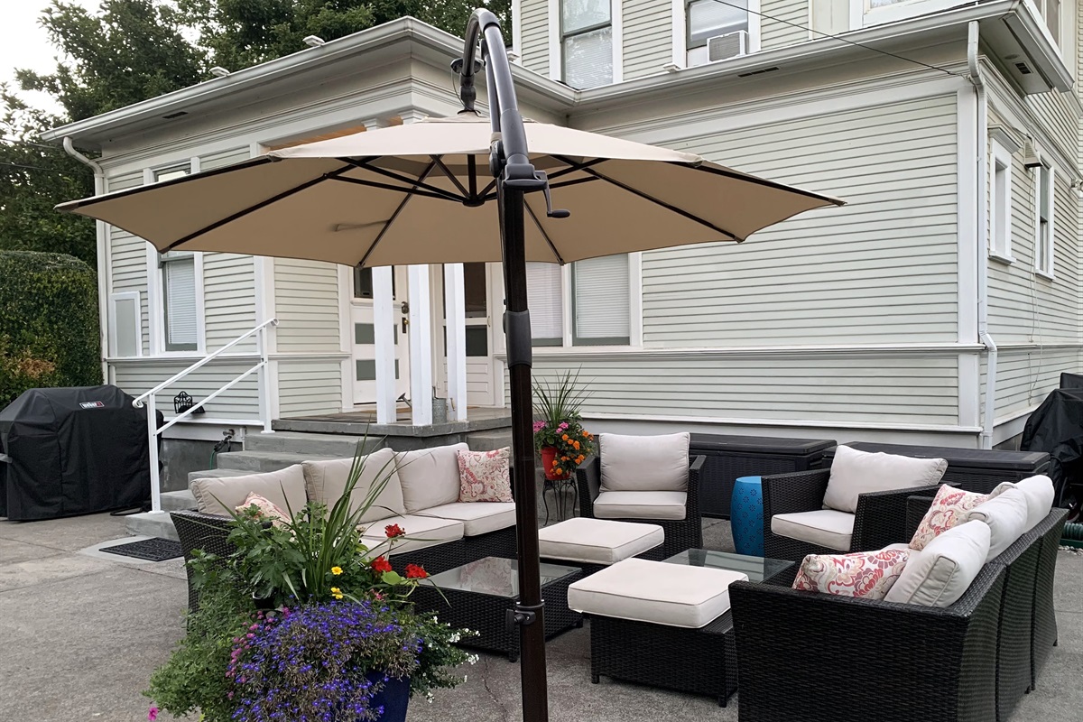 Back patio, surrounded by mature trees and historic charm and equipped with lounge seating and BBQ (propane provided)