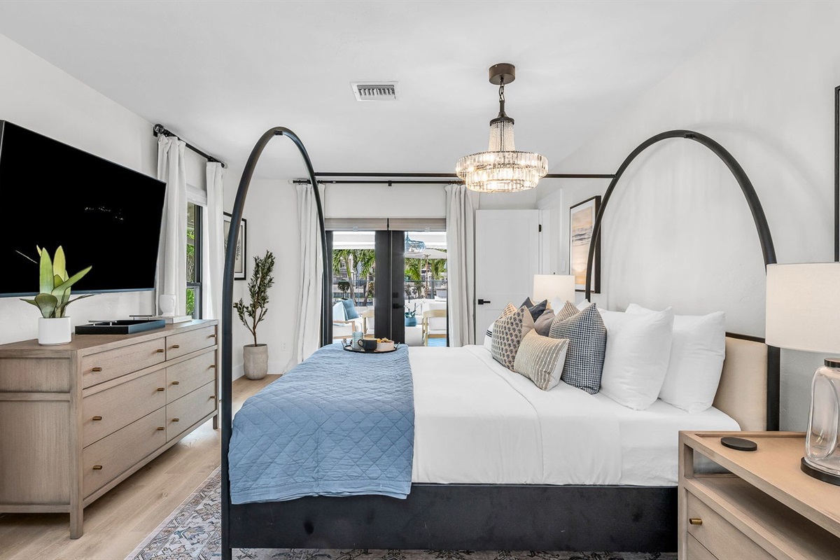 This second primary suite offers a plush king bed, private ensuite bathroom, and walk-in closet for added comfort. Enjoy poolside views and direct access to the outdoor living area, making it the perfect blend of luxury and convenience.