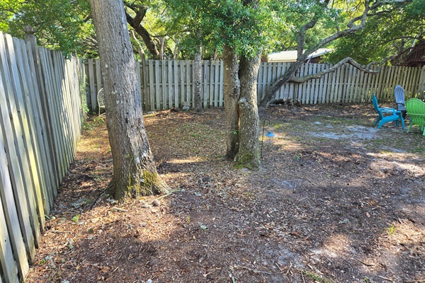 Large fenced in backyard with beautiful live oak trees