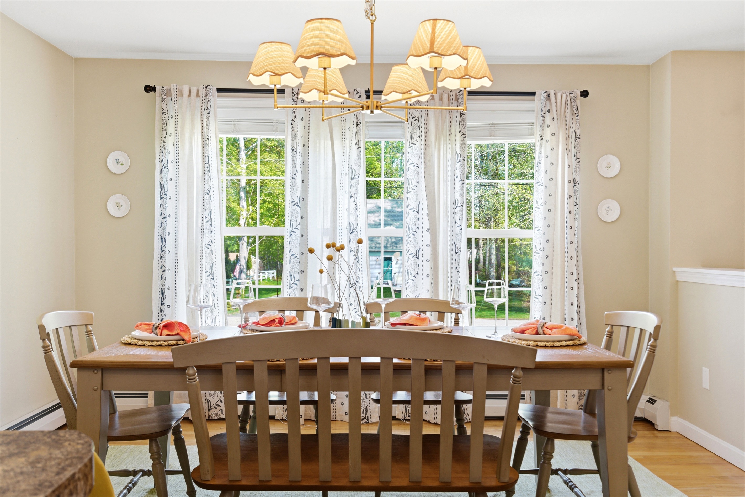 A bright and spacious dining area filled with natural light from surrounding windows, beautifully set with elegant cutlery for a welcoming dining experience.
