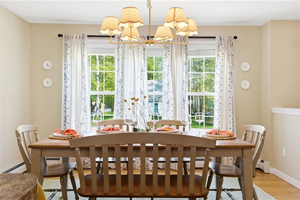 A bright and spacious dining area filled with natural light from surrounding windows, beautifully set with elegant cutlery for a welcoming dining experience.