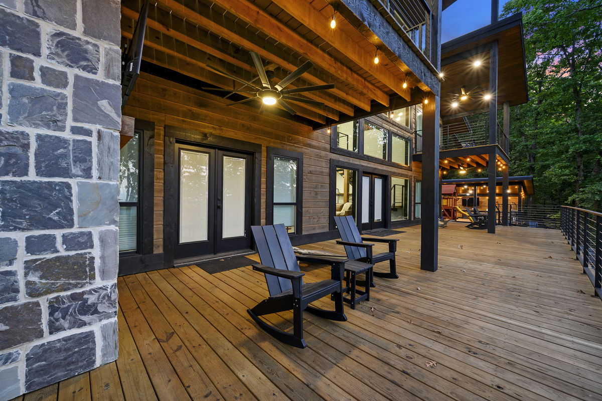 The huge main deck is made for relaxing and entertaining, with a fireplace, TV, cornhole, seating, and incredible mountain views.