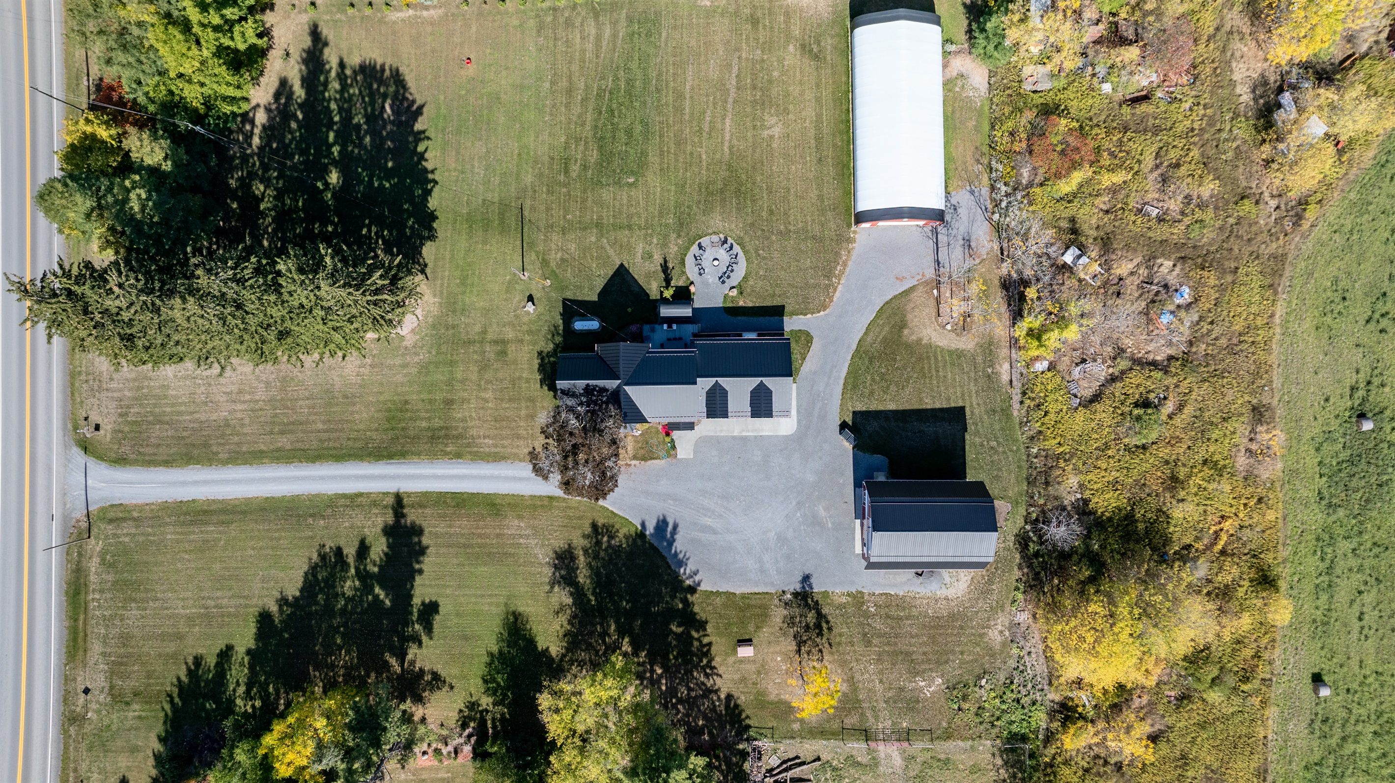 Aerial view showcasing the spacious Finger Lakes property with charming farmhouse and classic red barn
