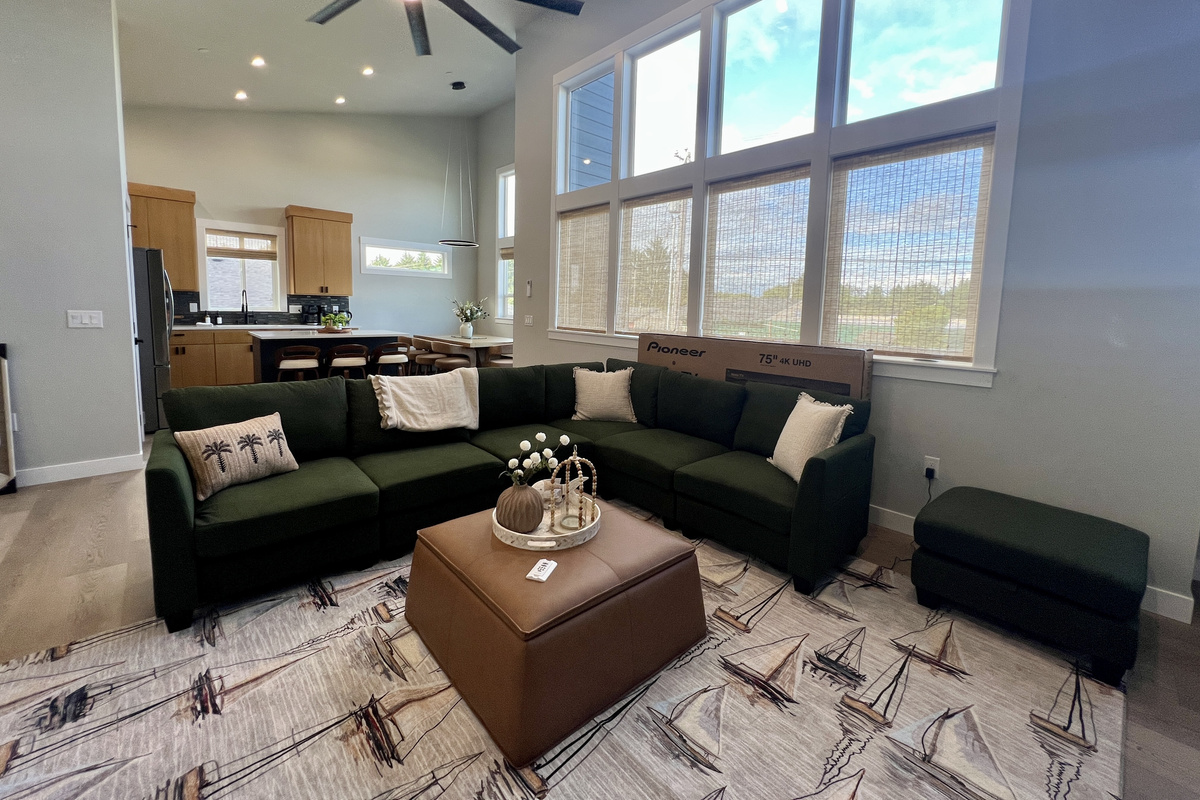 Up on the main level, soaring vaulted ceilings and walls of windows fill the open living space with light.
