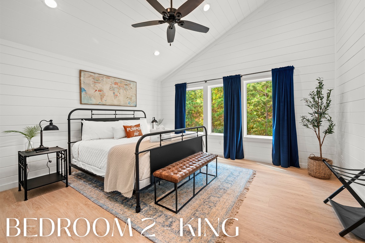 Bedroom 2 with king bed and forest views.
