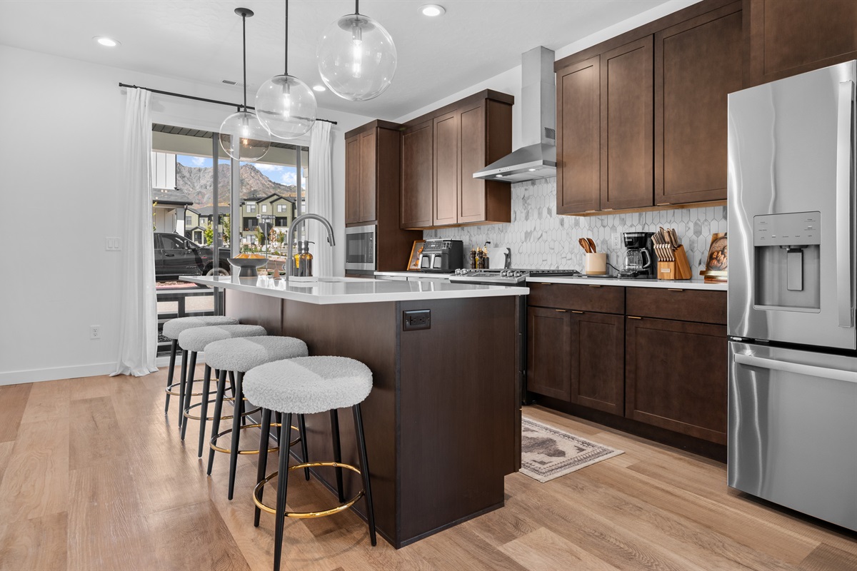Natural light pours in through sliding glass doors, connecting the kitchen seamlessly to the patio and mountain views.