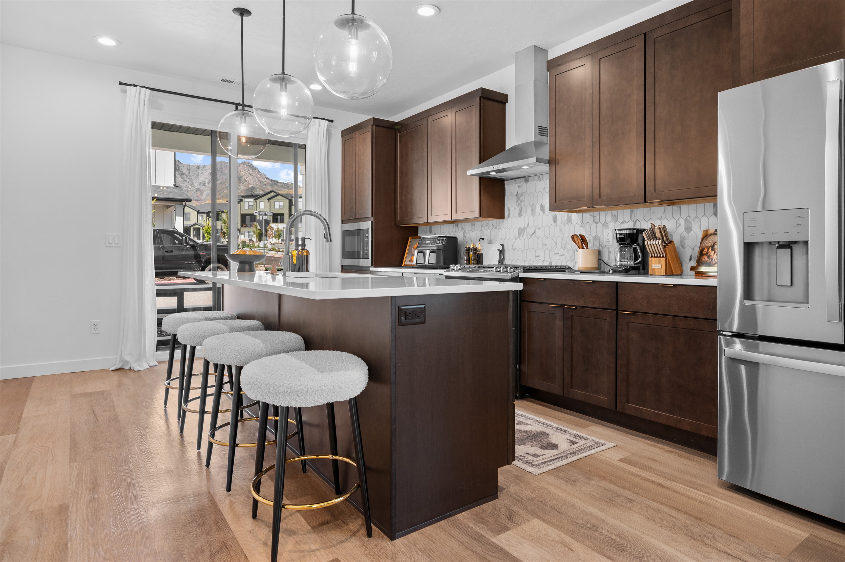 Natural light pours in through sliding glass doors, connecting the kitchen seamlessly to the patio and mountain views.