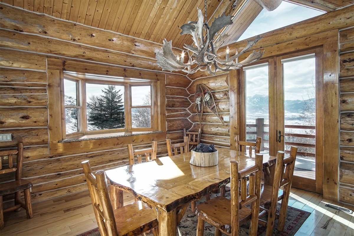 Charming dining area with log accents and access to the outdoor deck