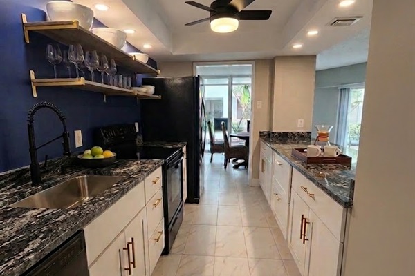 Kitchen with 4 barstools on other side, new appliances, water/ice maker on fridge.