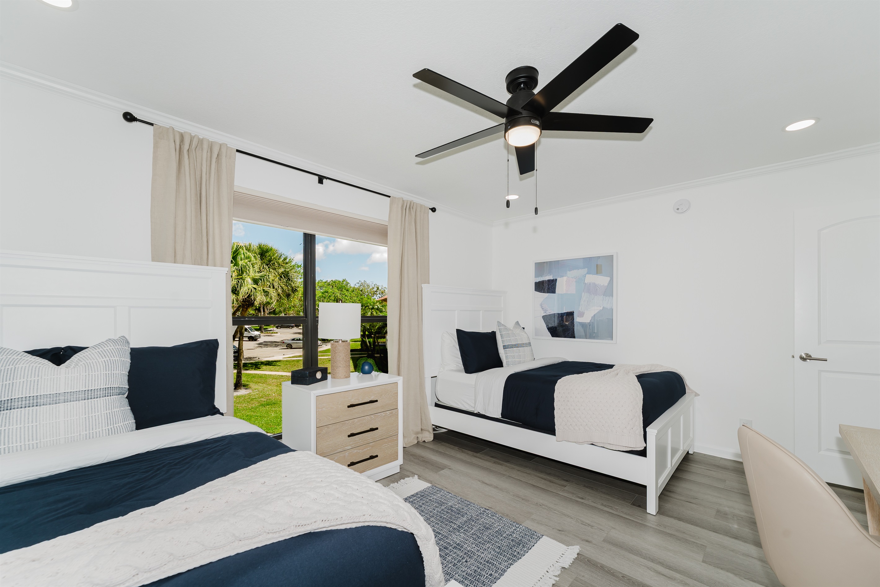 Cozy guest double queen bedroom with comfortable bedding and ample storage. Perfect space for family or friends to unwind and relax. Bright and inviting guest room with stylish touches.