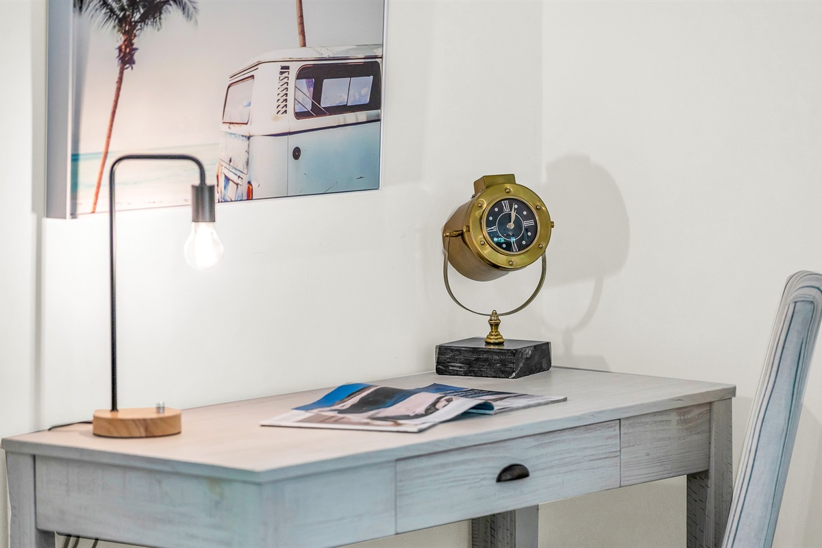 This bright and stylish workspace featuring a sleek modern desk and nautical-inspired decor, offers the perfect spot to stay productive while away from home, blending functionality with relaxed luxury,