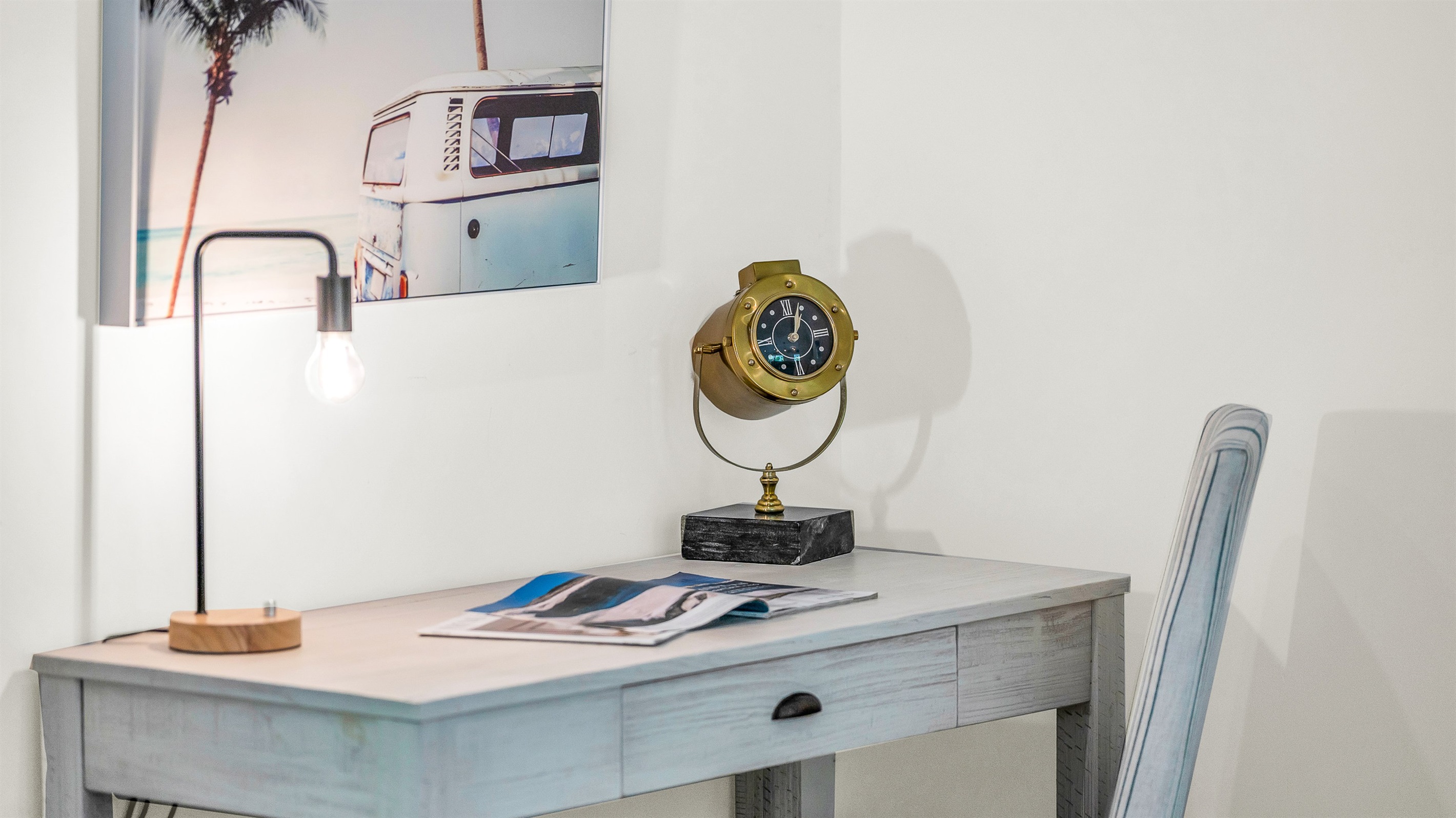 This bright and stylish workspace featuring a sleek modern desk and nautical-inspired decor, offers the perfect spot to stay productive while away from home, blending functionality with relaxed luxury,