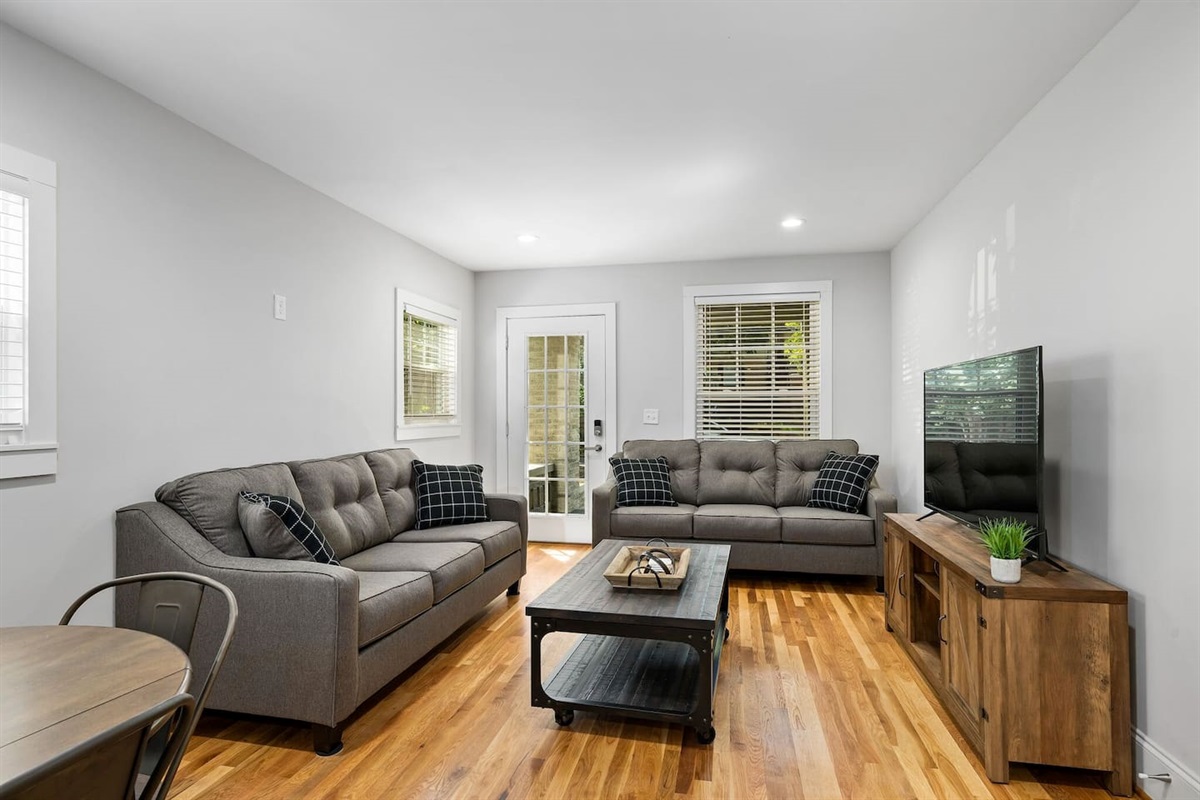 A seamless flow from the living room to the kitchen, highlighted by sleek, modern decor and a comfortable seating area perfect for socializing and relaxation.