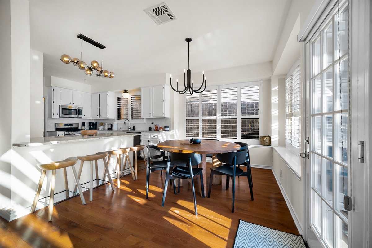 Warmly lit kitchen hub with island, bar chairs, and a circular dining nook