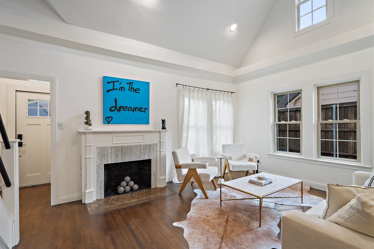 Living room with fireplace as decor only, hardwood floors, and curated furnishings. 55-inch Smart TV with streaming, central AC and heat, high-speed Wi-Fi, and Ethernet connection. Main house, first floor.