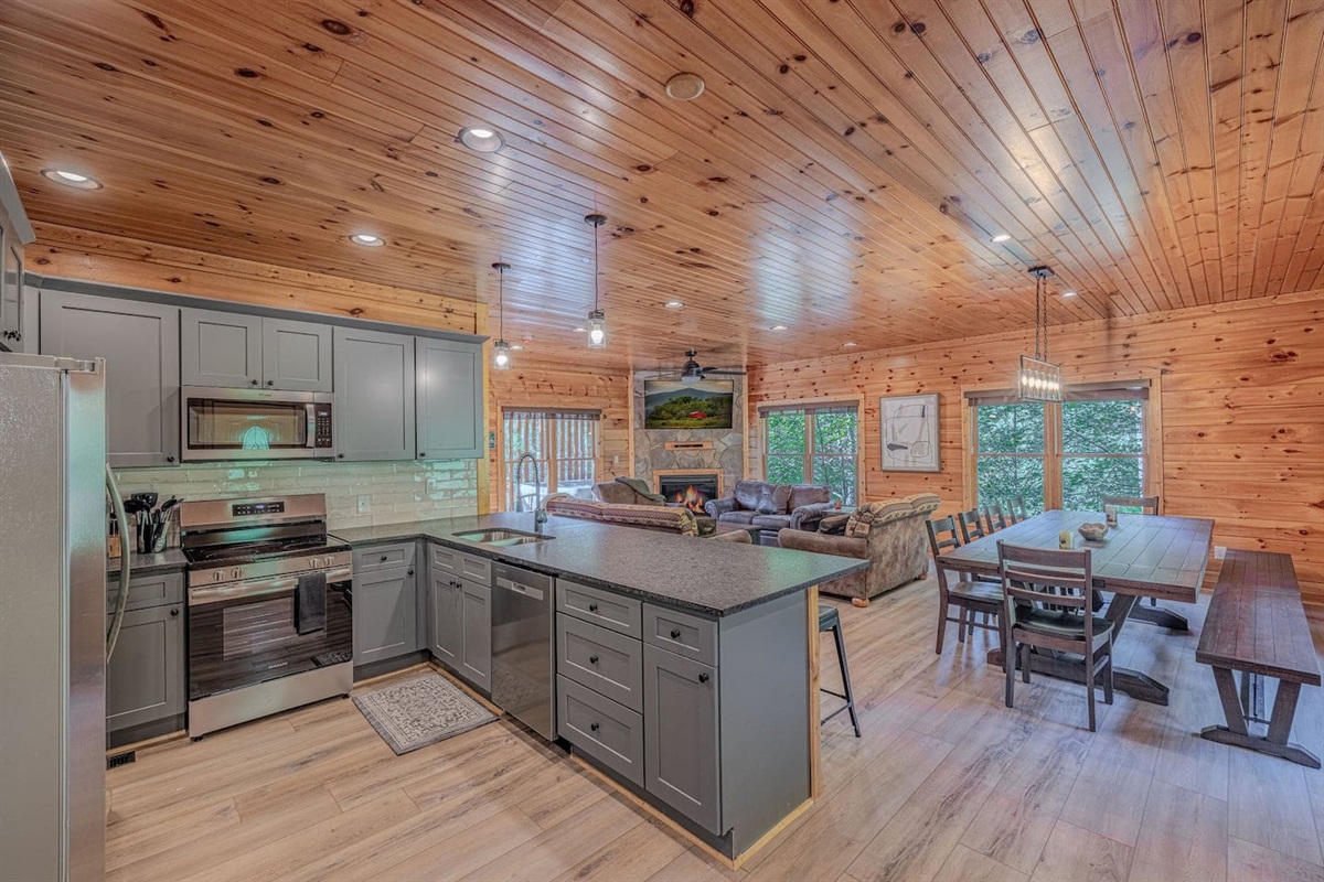 Fully equipped kitchen with granite island, 6-stool seating, stainless appliances, and everything needed to cook for 12. Luxury Gatlinburg cabin rental.