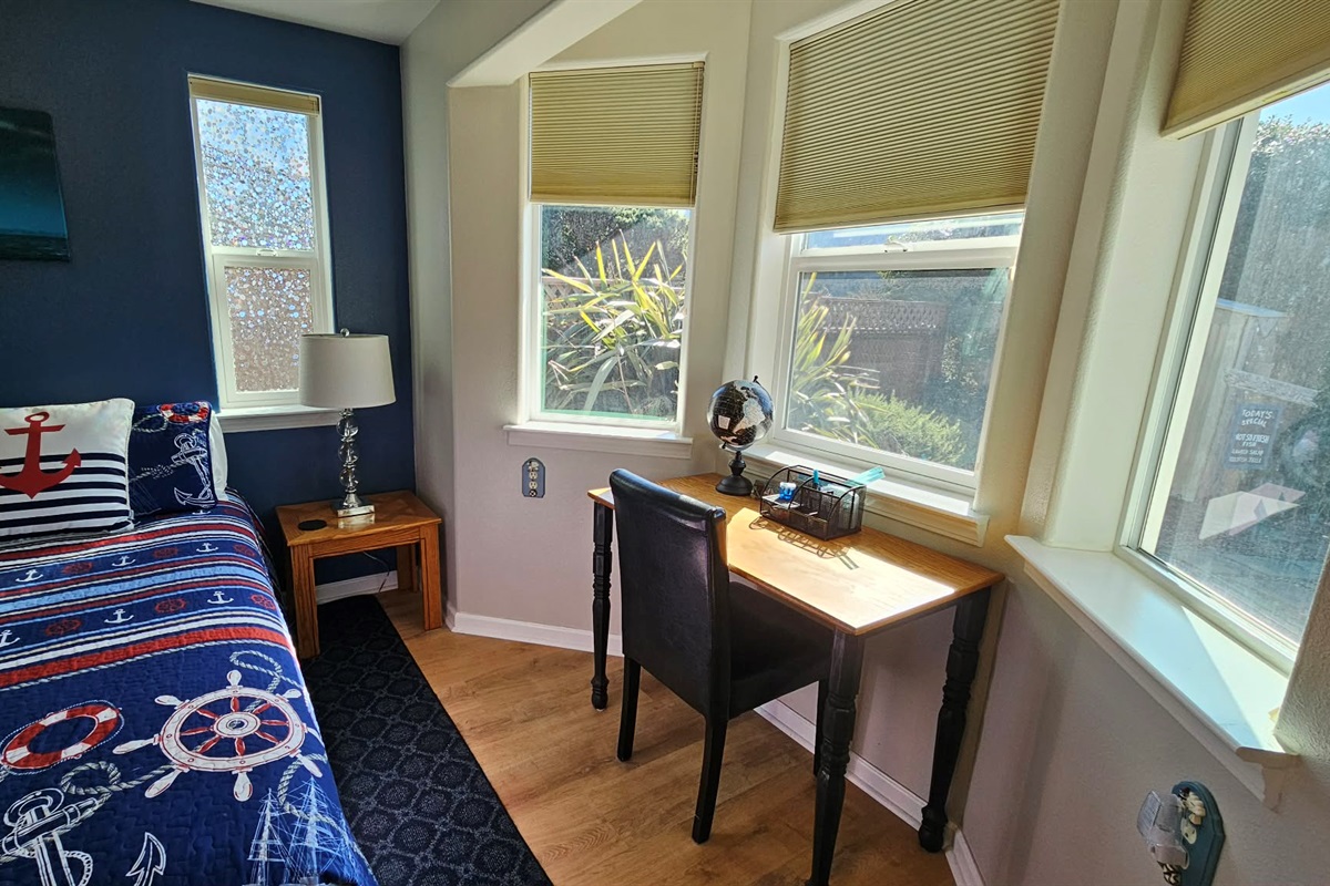 Desk in primary bedroom that looks onto backyard garden