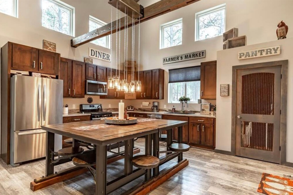 Open kitchen with island seating and high ceilings creating a bright gathering space.