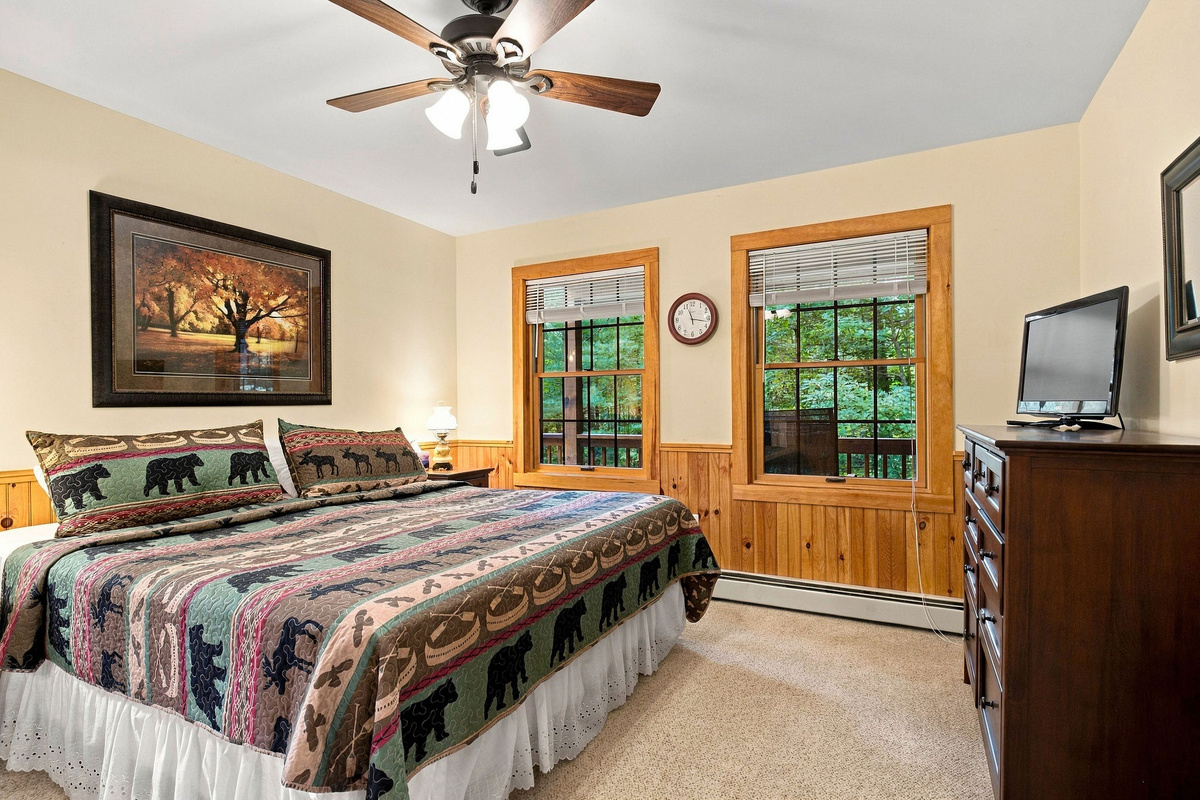 The primary bedroom includes a television, ceiling fan, and plenty of storage.
