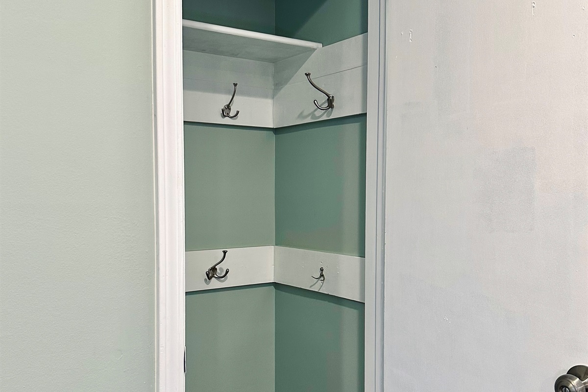 Spacious Entry coat closet with wall-mounted hooks and shelving, perfect for jackets, bags, and daily essentials. An easy drop zone that keeps the main living area uncluttered and organized.