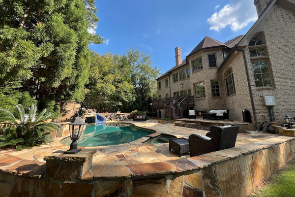 Backyard surround by supple trees for added privacy. Pristine salted pool. Waterfalls and grotto. Lots of outdoor seating & lounging areas.