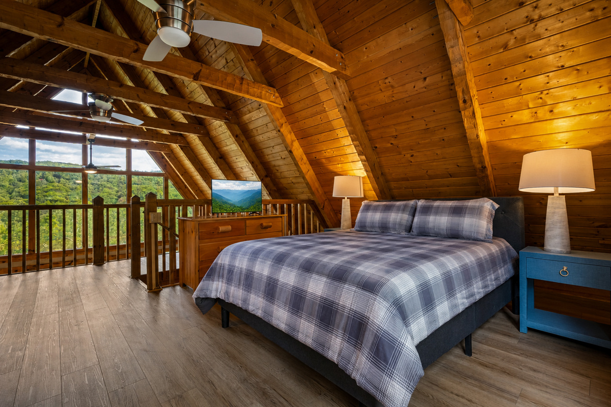 Upper level bedroom features a view of the mountains, a queen bed, and a smart TV