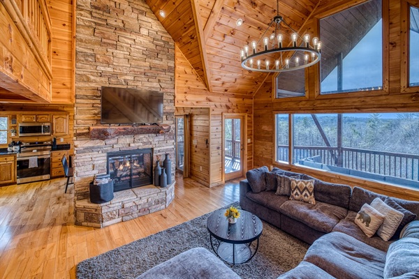 Main living room with beautiful A-frame ceiling, wall of windows, double-sided gas fireplace, and stunning mountain views! 