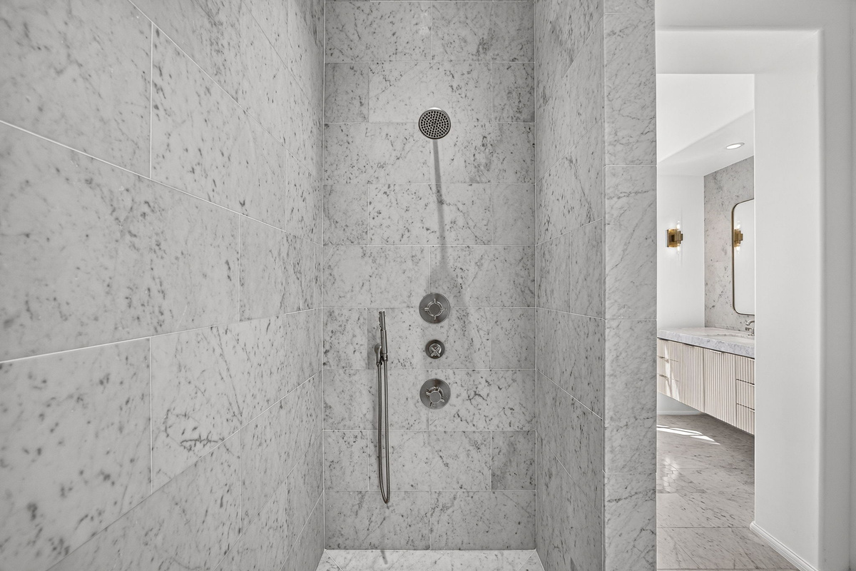 The luxurious marble shower is located in the primary bathroom.