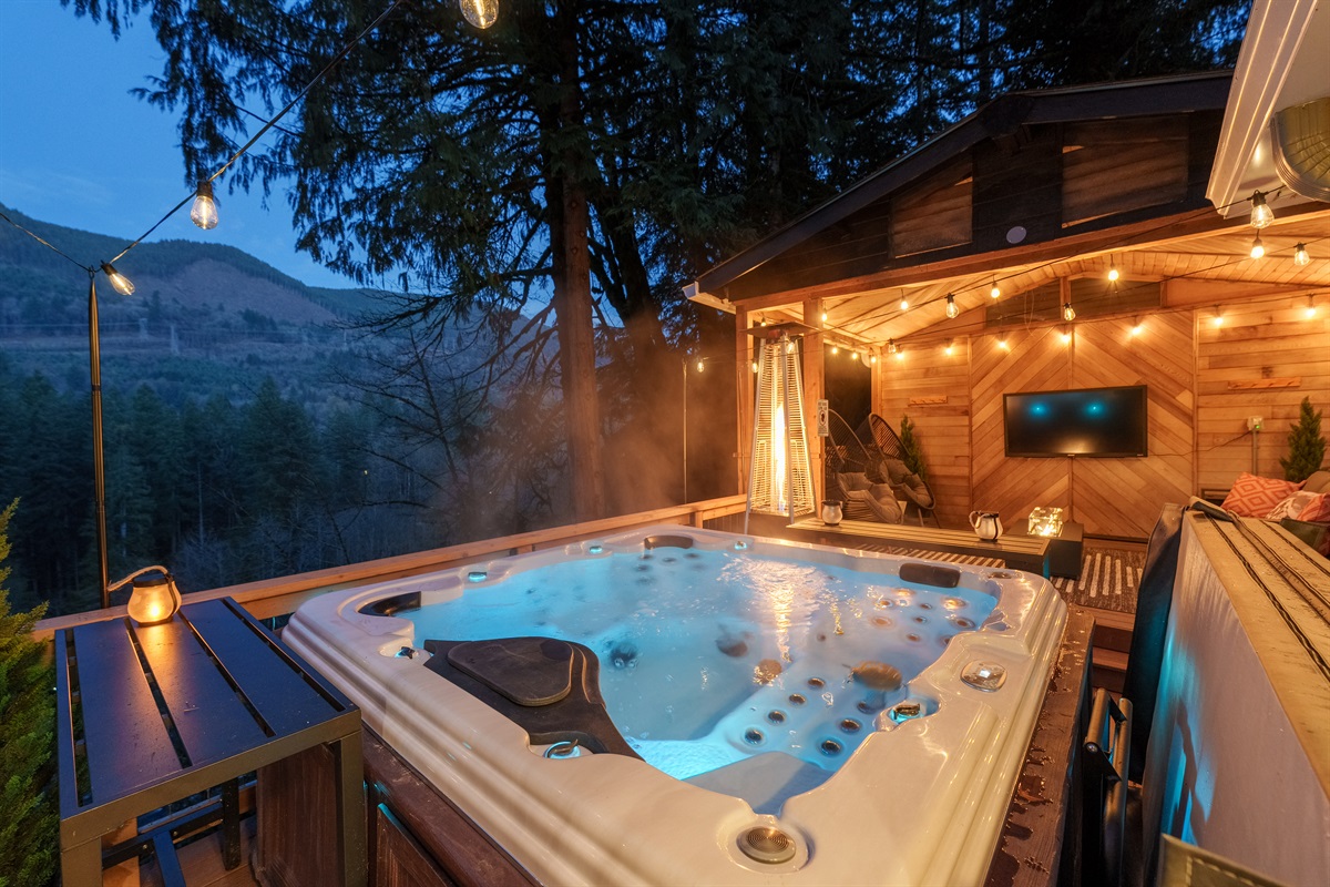 A spa-style hot tub with mountain views and a glowing lounge nearby creates the ultimate luxury escape—ideal for unwinding after skiing, biking, or exploring Mt. Hood.