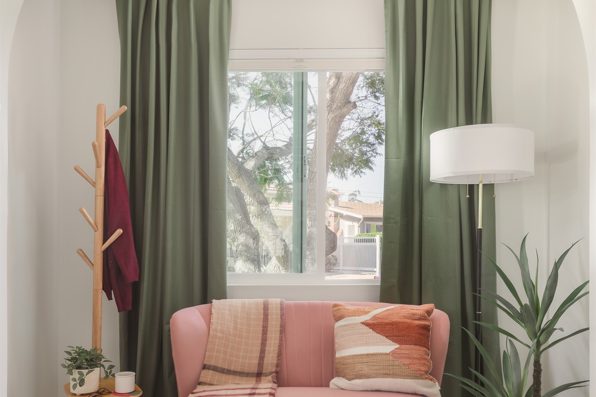 Start your morning with coffee and sunlight in this dreamy reading nook, where cozy textures, soft colors, and leafy views create a peaceful escape