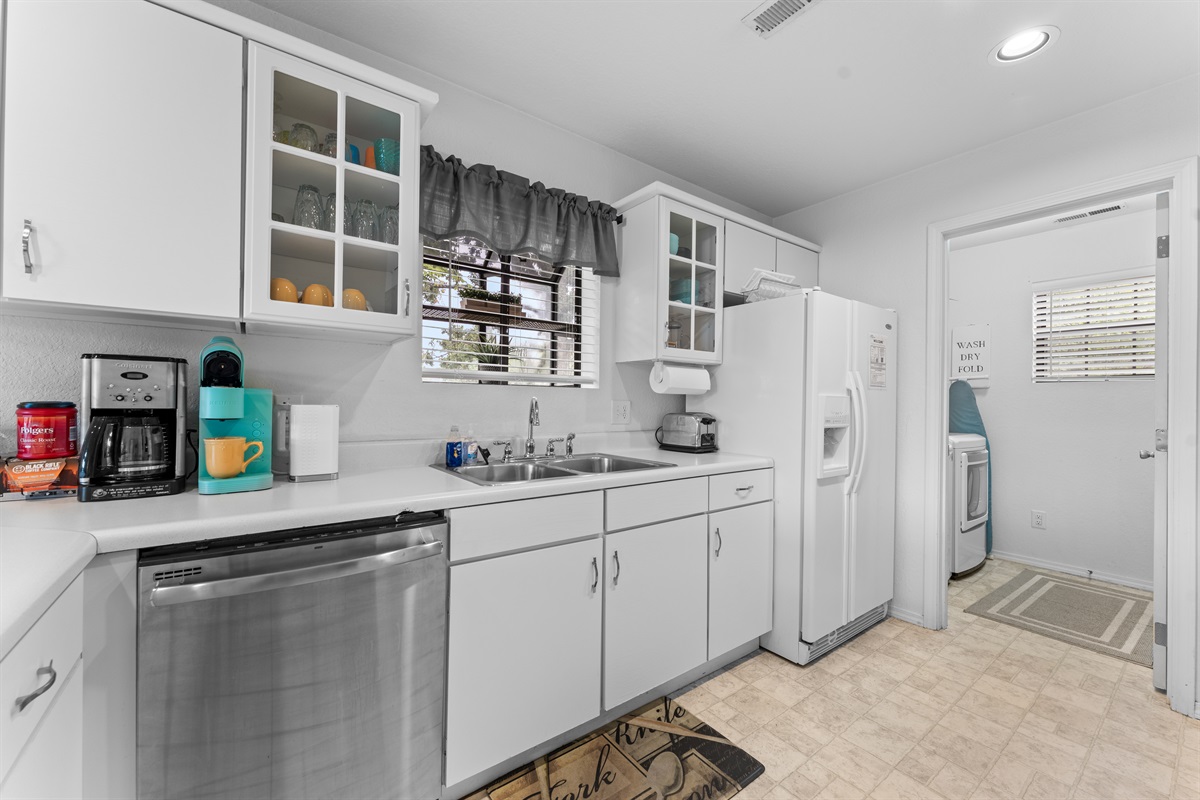 Another look at the well-stocked kitchen, with easy access to coffee, cleanup, and the in-unit laundry area.