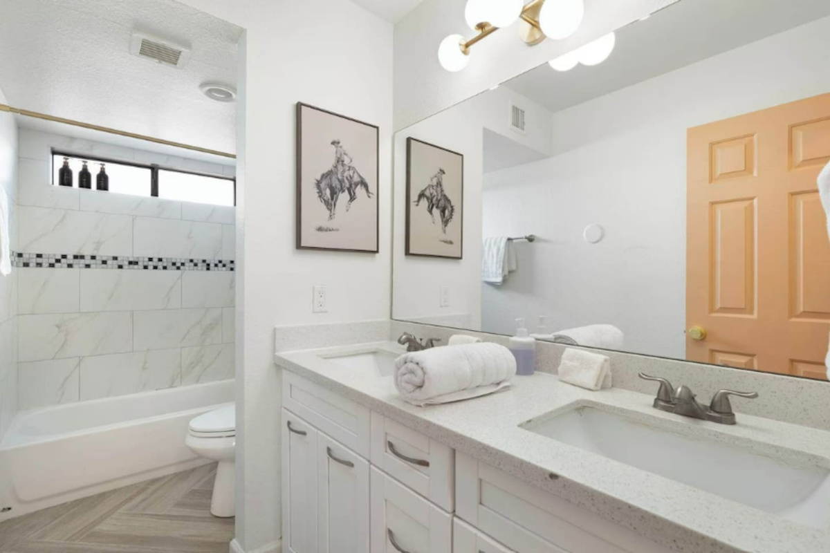 Custom tiled shower with tub and dual vanities.