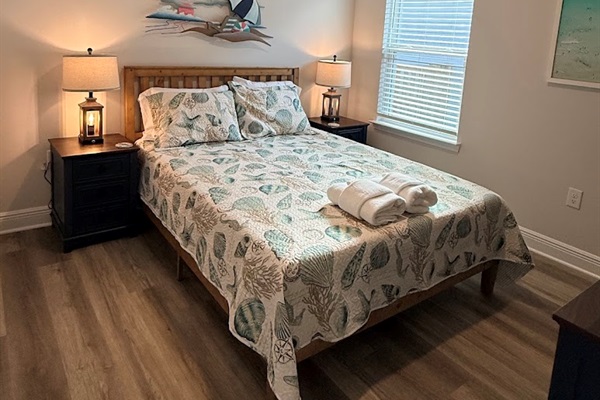 Cozy queen bedroom with stylish décor and comfortable bedding.