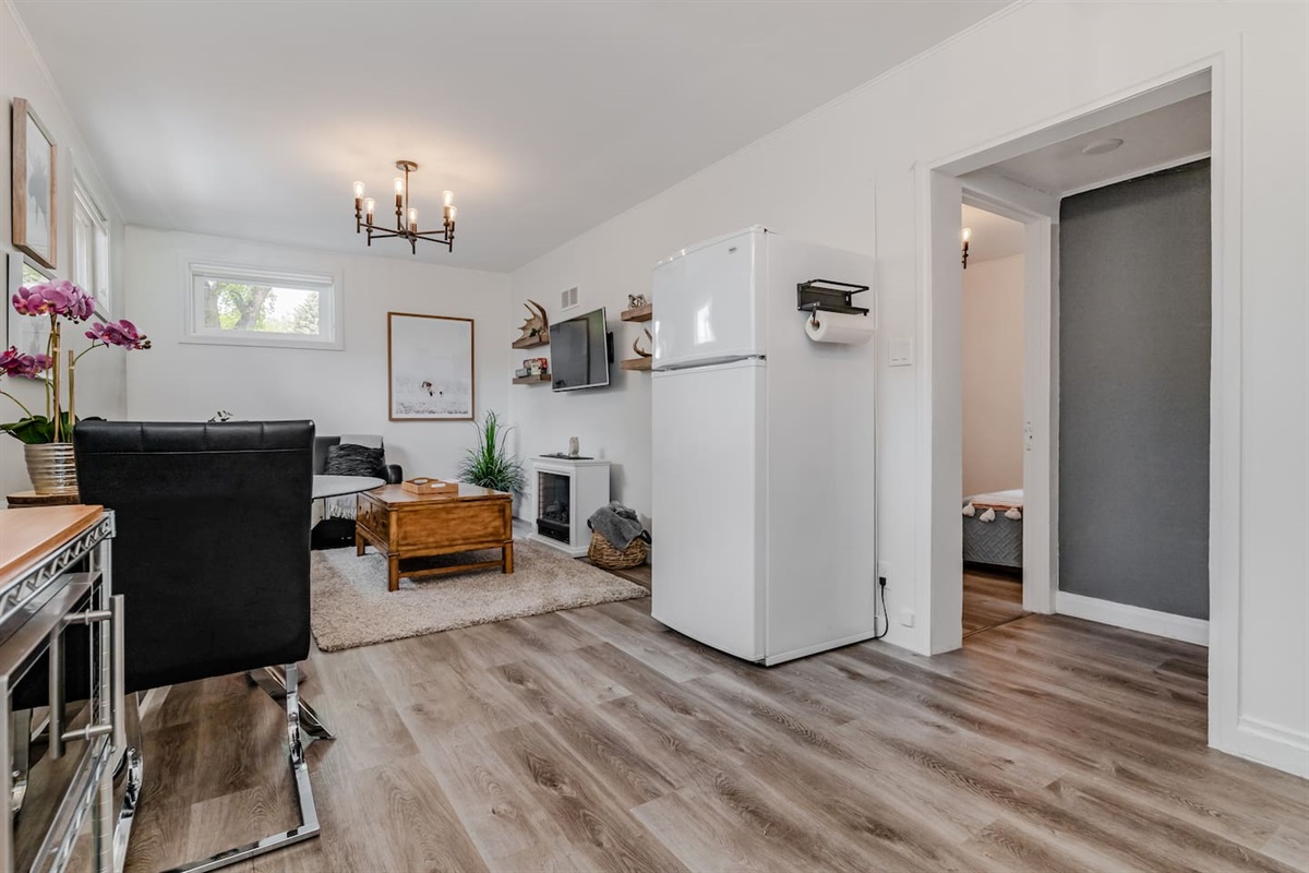Open-concept basement living area with seating and Smart TV