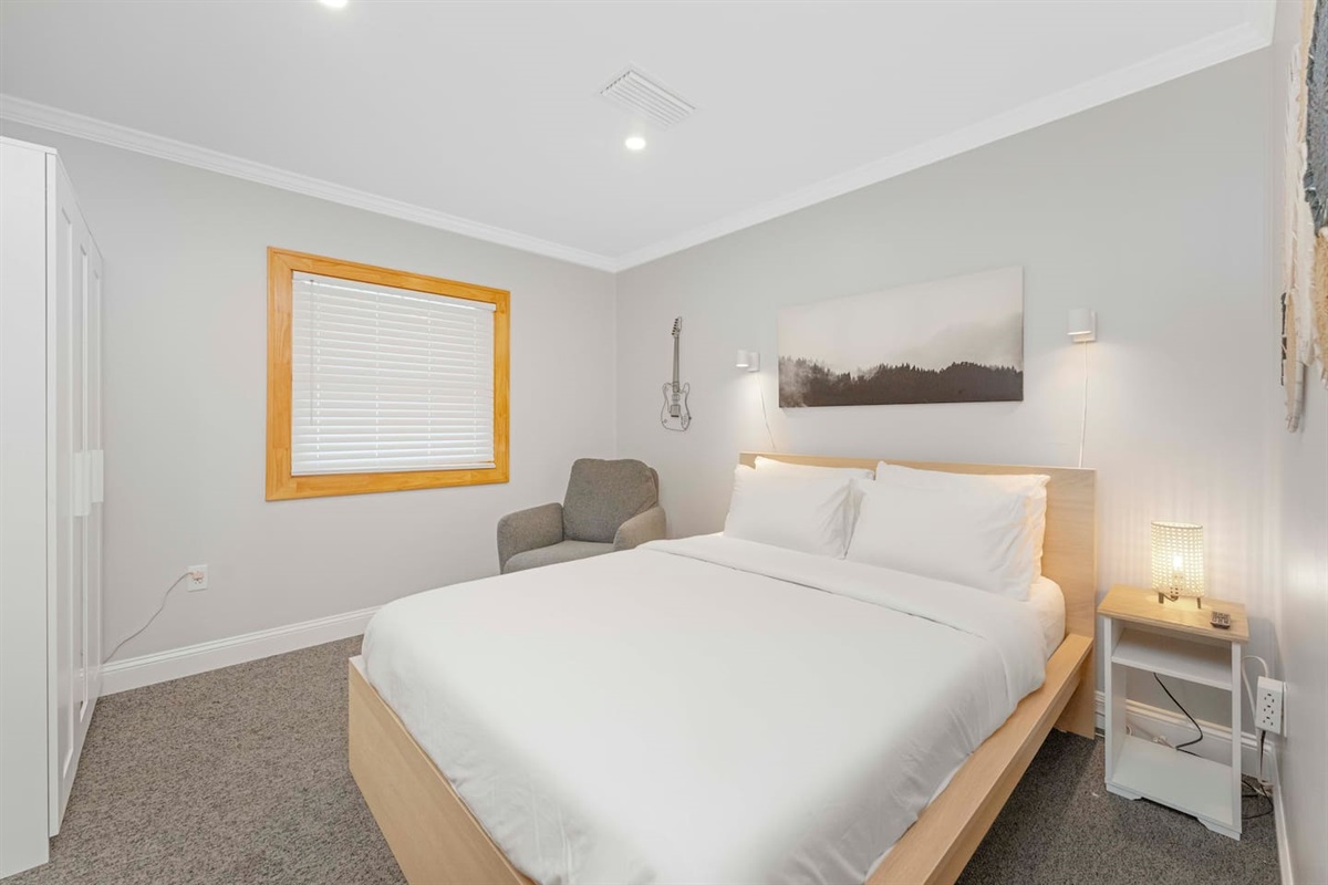 Guest bedroom with queen bed and wardrobe for clothing storage