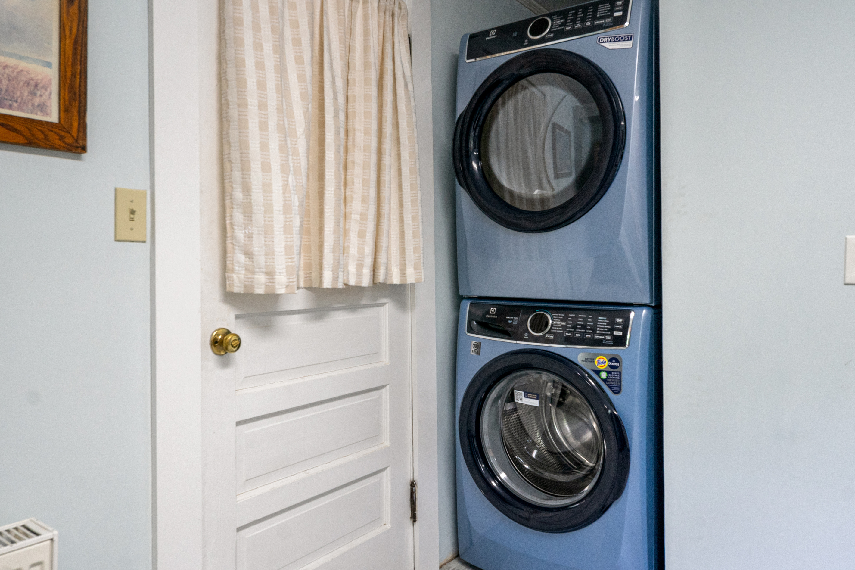 Positioned directly next to the mudroom entry door, this alcove features a full-size, stacked Electrolux washer and dryer. This layout allows you to drop damp towels or outdoor gear straight into the wash the moment you step inside.