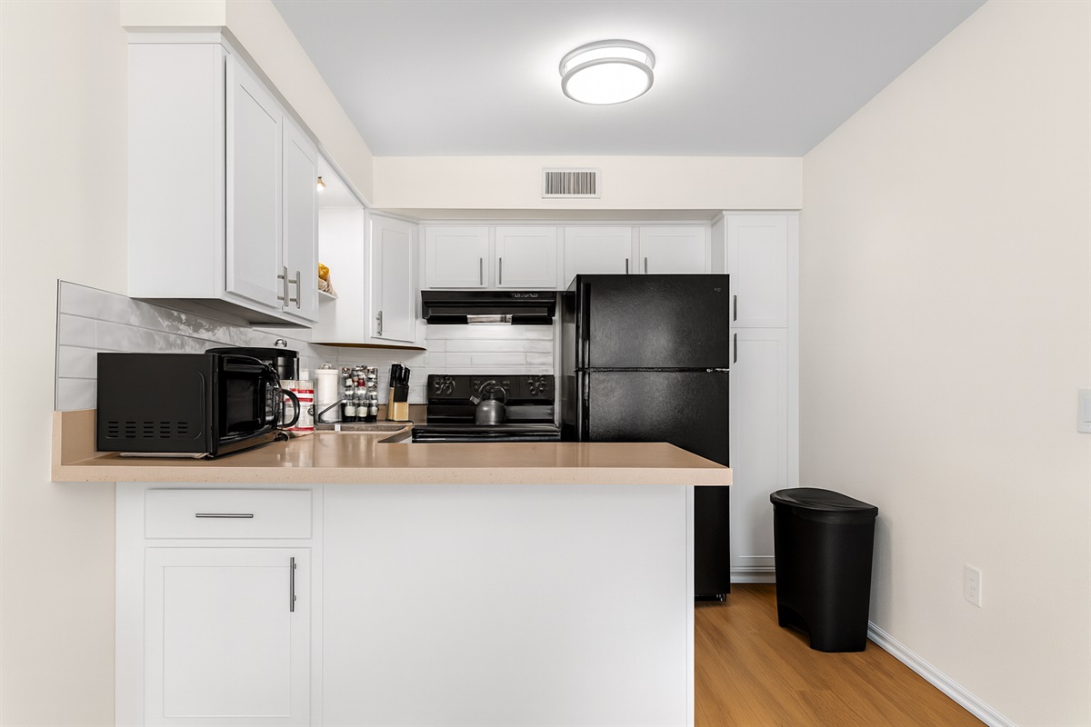 Sleek kitchen with modern appliances, ample counter space, and fully stocked essentials—perfect for cooking meals and enjoying a comfortable stay.
