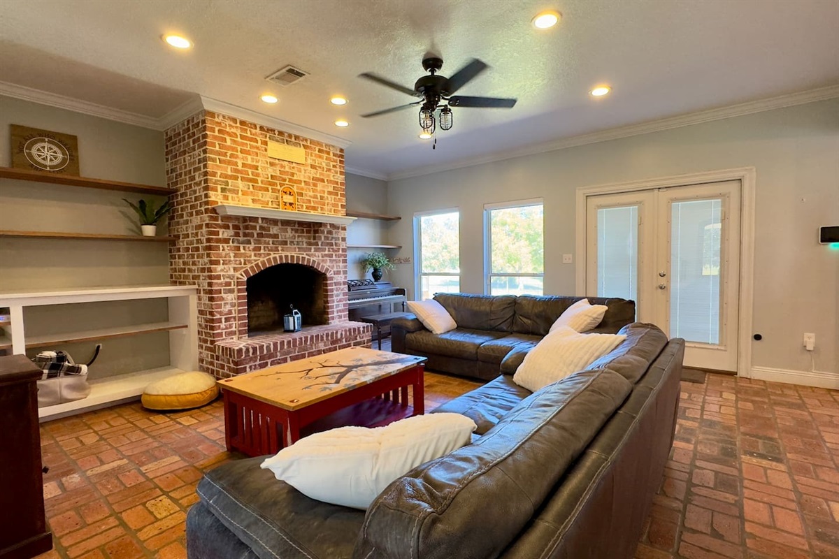 A spacious living room centered around a striking brick fireplace, perfect for evenings spent together