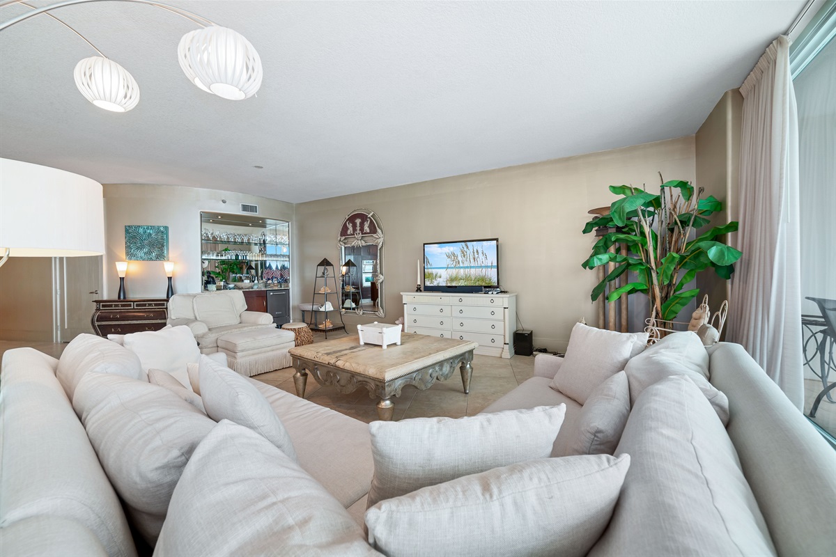 Spacious and inviting living area with floor-to-ceiling windows showcasing breathtaking panoramic views. This open-concept design seamlessly blends comfort and style, creating the perfect space for relaxation and entertainment.